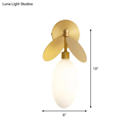 Modern brass leaf wall lamp with cream glass bedroom sconce