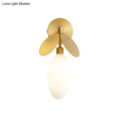 Modern brass leaf wall lamp with cream glass bedroom sconce