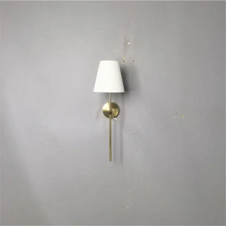 Modern brass led wall sconce with white fabric shade for bedroom