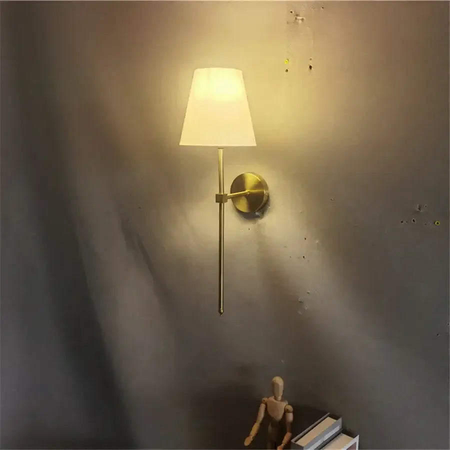 Modern brass led wall sconce with white fabric shade for bedroom