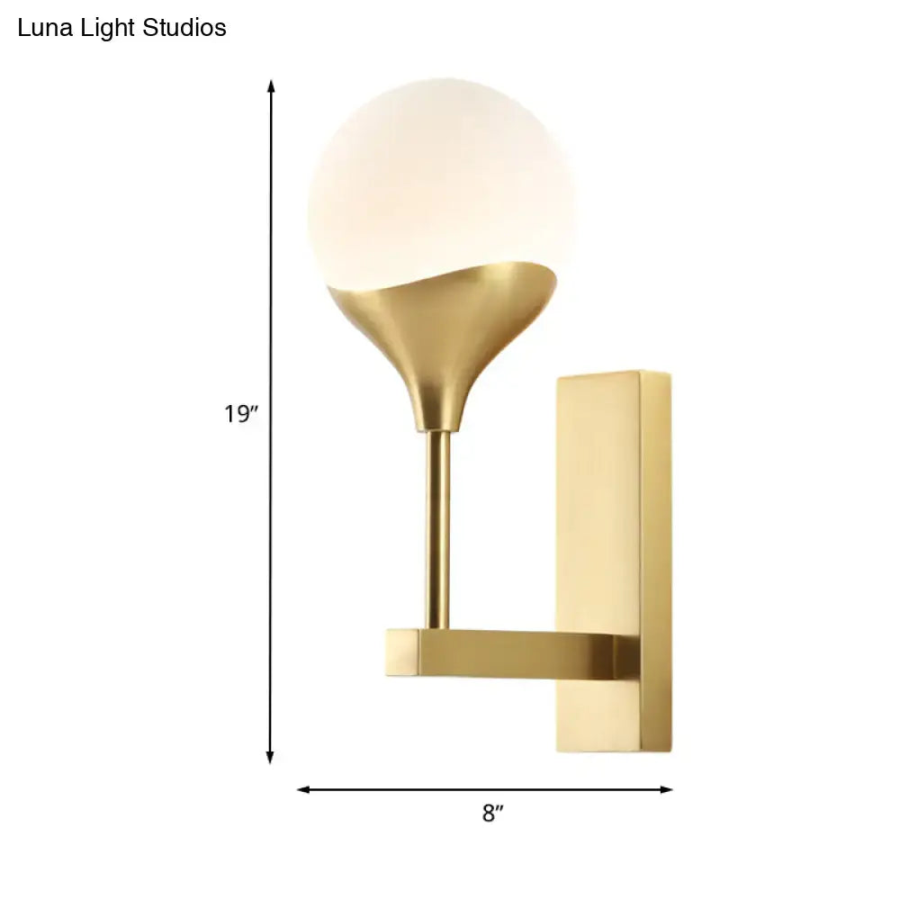 Modern brass wall lamp with cream glass shade – bedroom