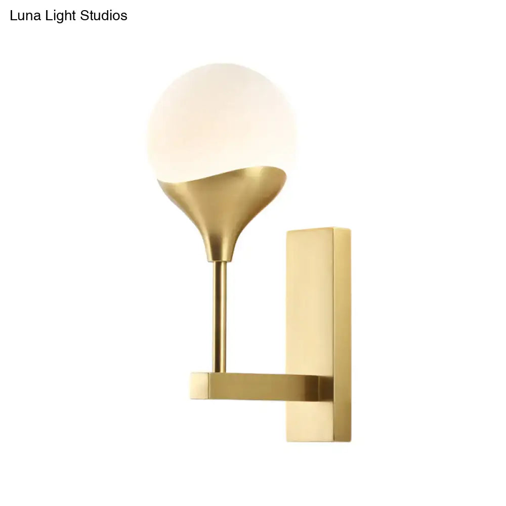 Modern brass wall lamp with cream glass shade – bedroom