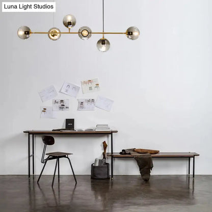 Modern gold and smoke gray globe hanging light – dining room island
