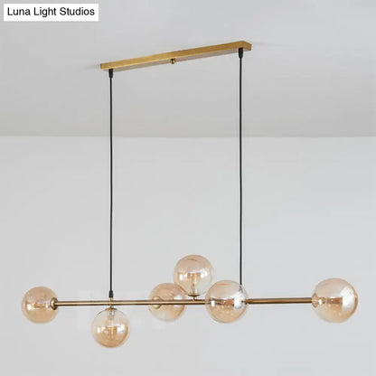 Modern gold metal island pendant with blue glass spheres dining room