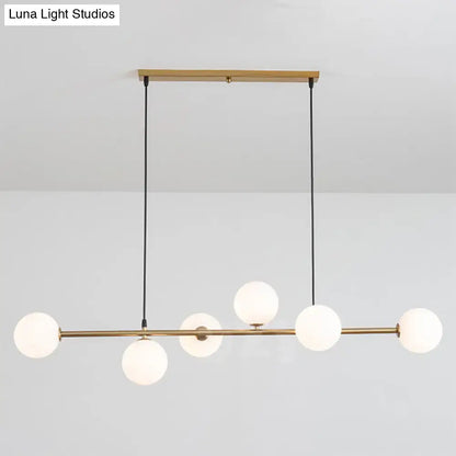 Modern gold metal island pendant with blue glass spheres dining room