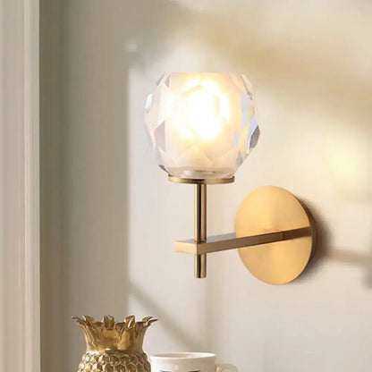 Modern gold wall lamp with faceted globe shade for hallway