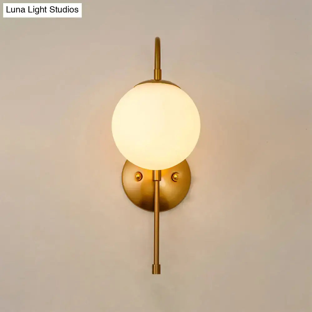 Modern golden gooseneck wall sconce with frosted glass ball bedroom