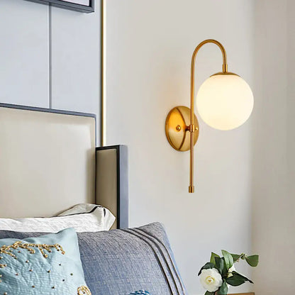 Modern golden gooseneck wall sconce with frosted glass ball bedroom