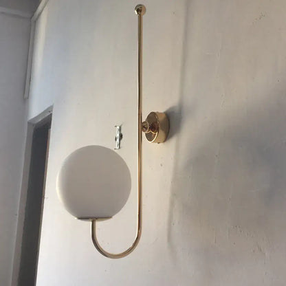 Modern golden gooseneck wall sconce with frosted glass ball bedroom