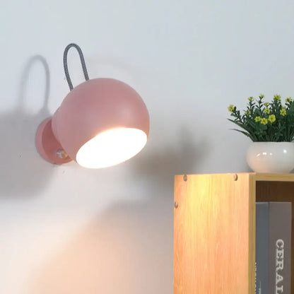 Modern pink spherical wall lamp with flexible black cord living room