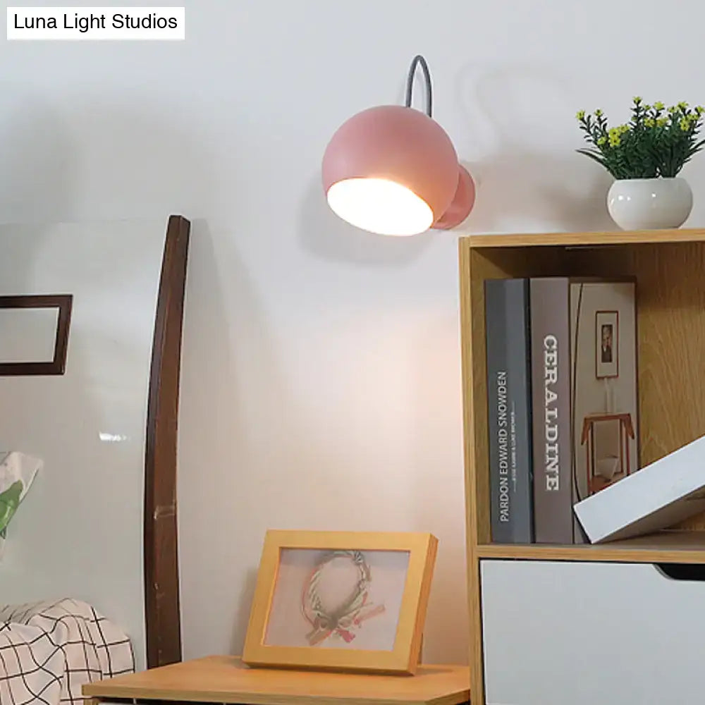 Modern pink spherical wall lamp with flexible black cord living room