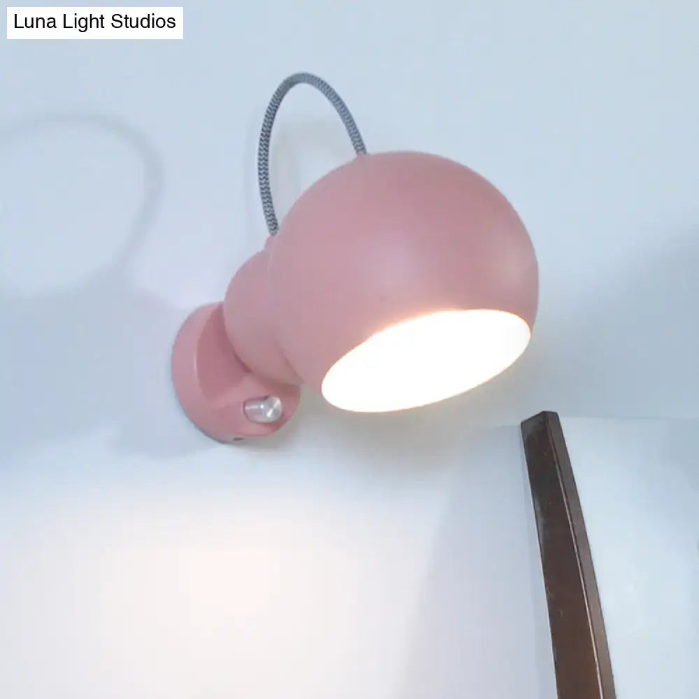 Modern pink spherical wall lamp with flexible black cord living room