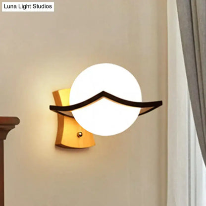 Modern white glass ball sconce with black accent for bedroom
