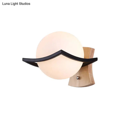 Modern white glass ball sconce with black accent for bedroom