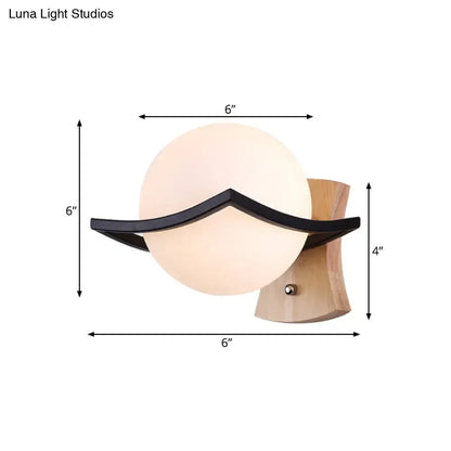 Modern white glass ball sconce with black accent for bedroom