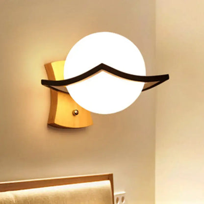 Modern white glass ball sconce with black accent for bedroom