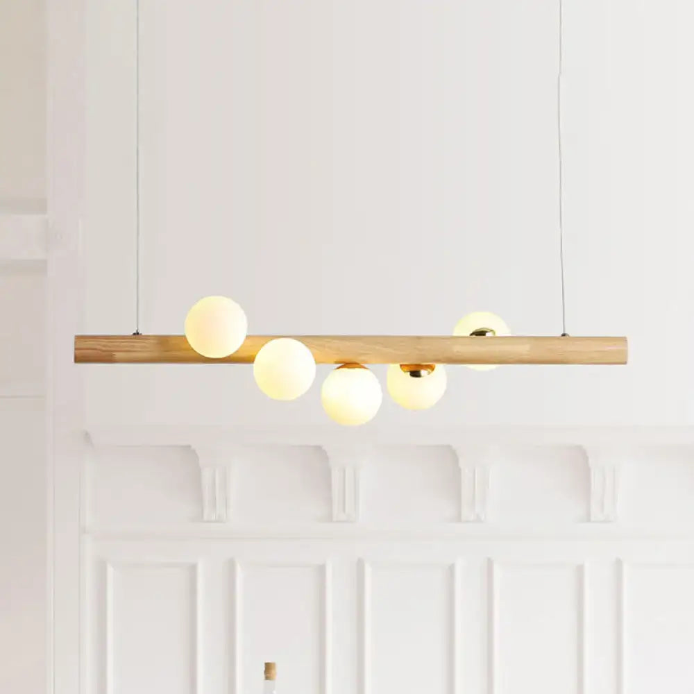 Modern wood island light with opal glass spheres for dining room
