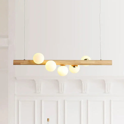 Modern wood island light with opal glass spheres for dining room
