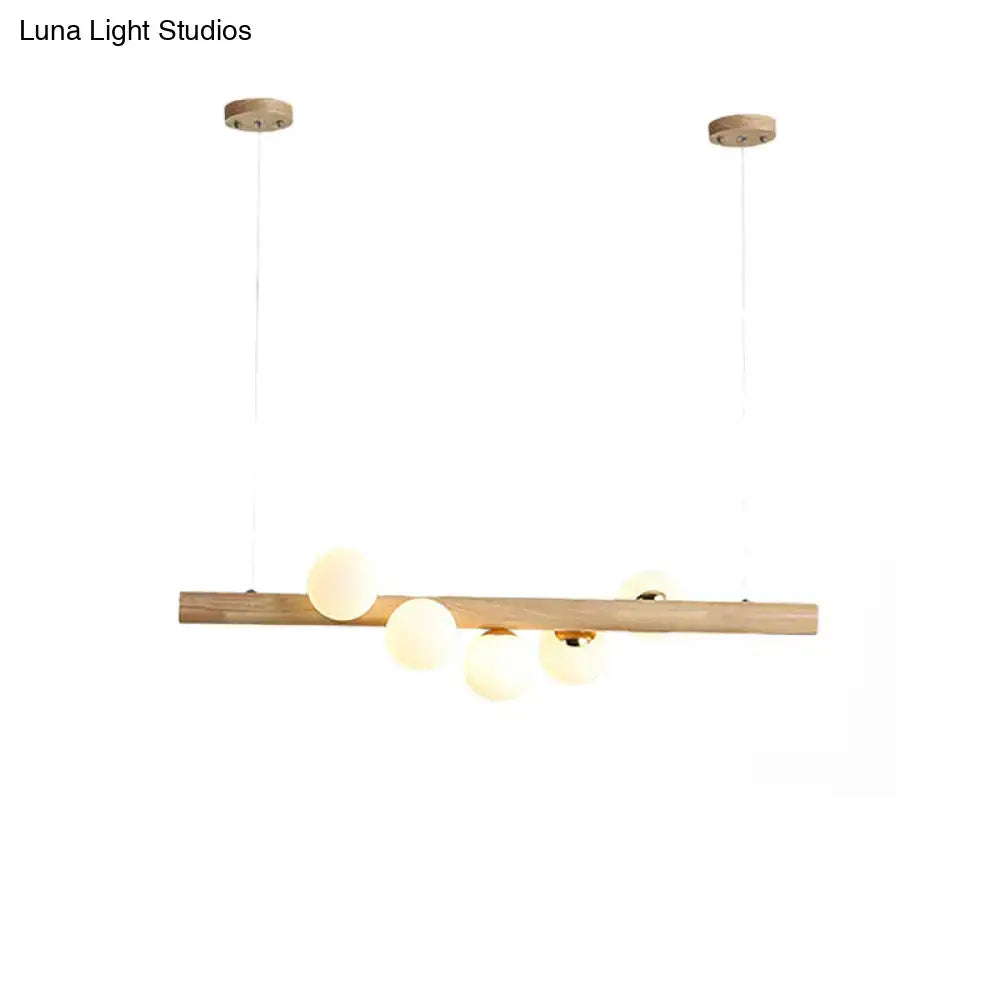Modern wood island light with opal glass spheres for dining room