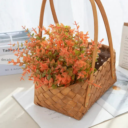 Orange & red artificial eucalyptus leaves in white pitcher – garden decor