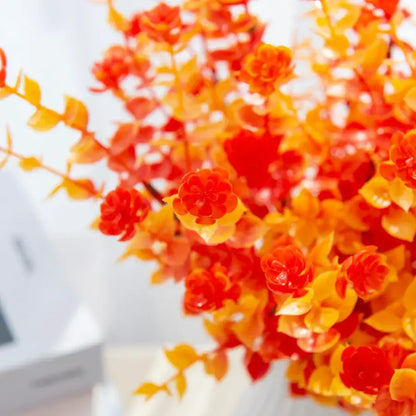 Orange & red artificial eucalyptus leaves in white pitcher – garden decor