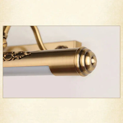 Ornate brass bathroom mirror lamp with decorative scrollwork