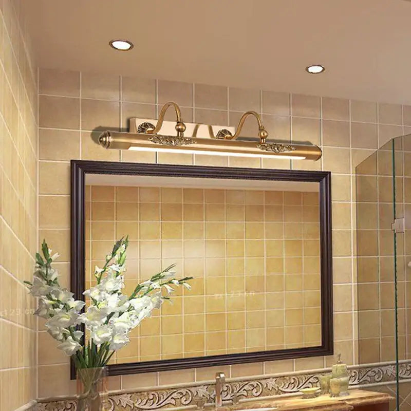 Ornate brass bathroom mirror lamp with decorative scrollwork