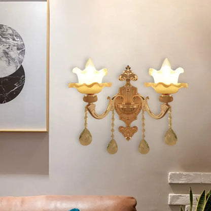 Ornate gold crystal wall sconce with frosted glass shade living room