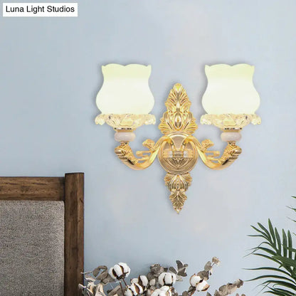 Ornate gold wall light with glass bloom shades – living room fixture