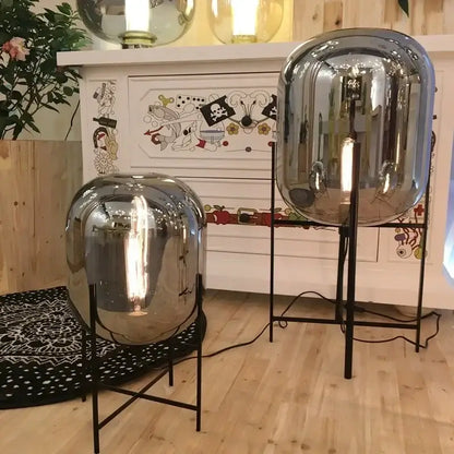 Postmodern amber glass ball floor lamp – living room black metal frame