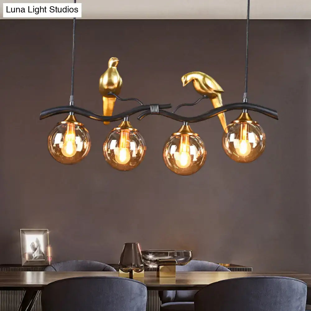 Postmodern black & gold bird pendant light with amber ball glass shade