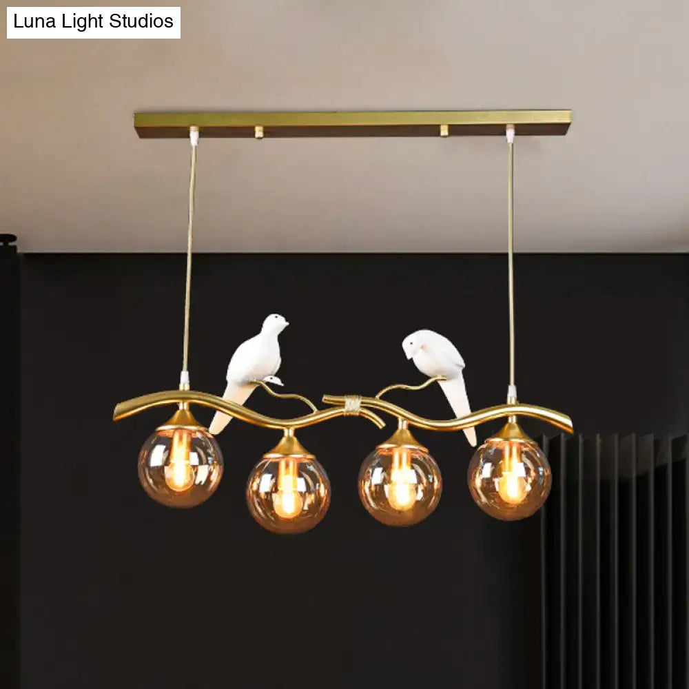 Postmodern black & gold bird pendant light with amber ball glass shade