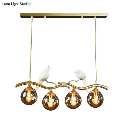 Postmodern black & gold bird pendant light with amber ball glass shade