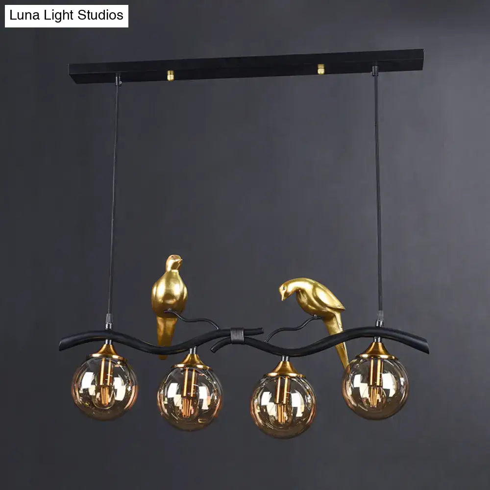 Postmodern black & gold bird pendant light with amber ball glass shade