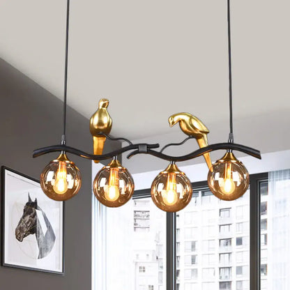 Postmodern black & gold bird pendant light with amber ball glass shade