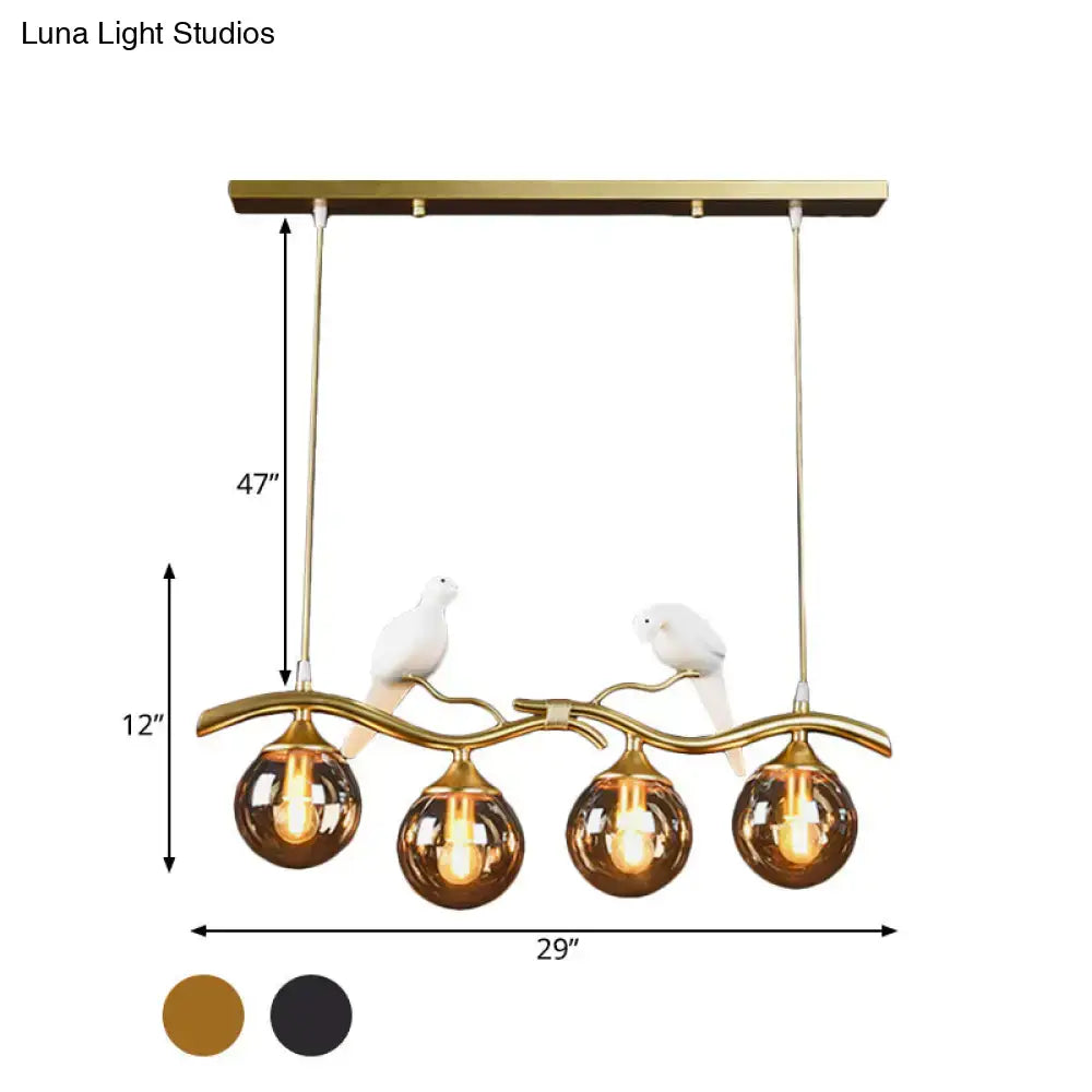 Postmodern black & gold bird pendant light with amber ball glass shade
