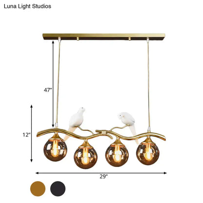 Postmodern black & gold bird pendant light with amber ball glass shade