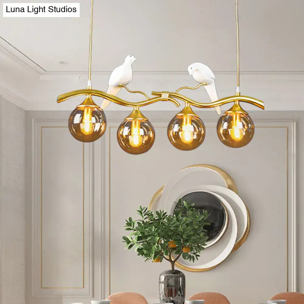 Postmodern black & gold bird pendant light with amber ball glass shade