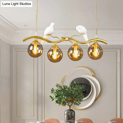 Postmodern black & gold bird pendant light with amber ball glass shade