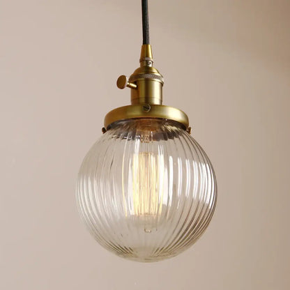 Ribbed glass globe pendant light with brass fixture for living room