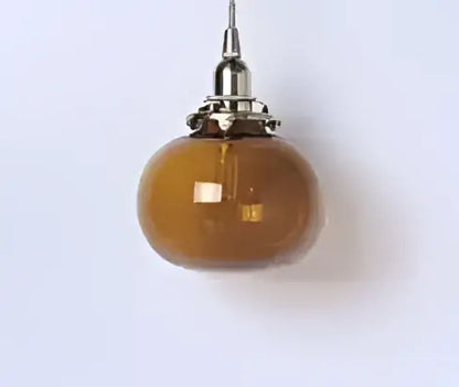 Teal blue glass pendant light with brass hardware for dining room