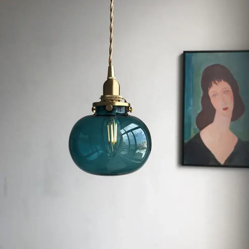 Teal glass ball pendant light with brass hardware for bedroom