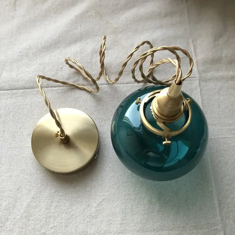 Teal glass ball pendant light with brass hardware for bedroom