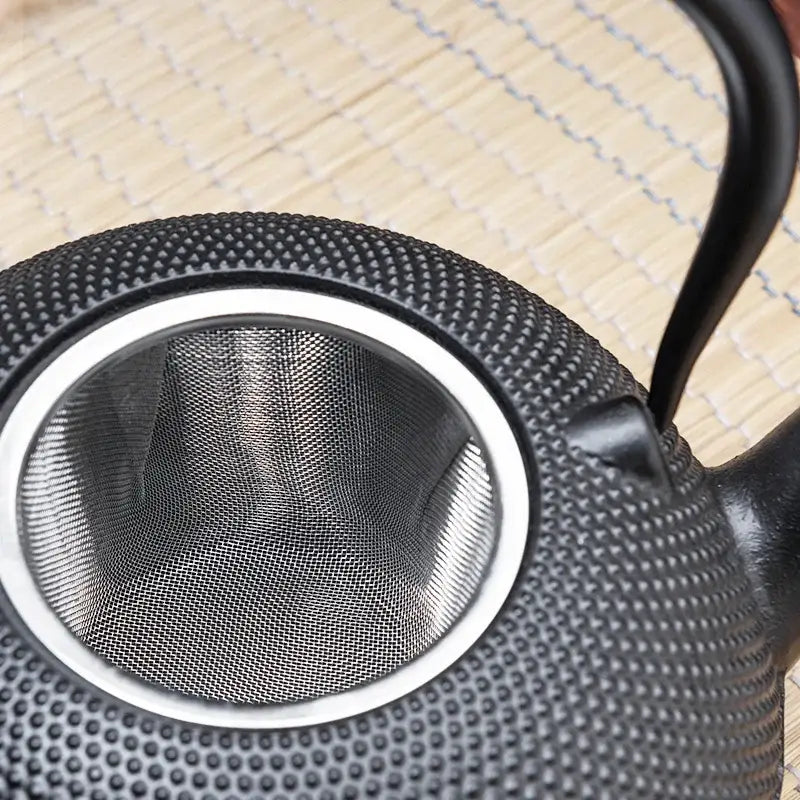 Textured black cast iron tea pot with infuser kitchen steeper