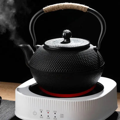 Textured black cast iron tea pot with infuser kitchen steeper