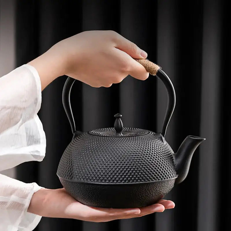 Textured black cast iron tea pot with infuser kitchen steeper