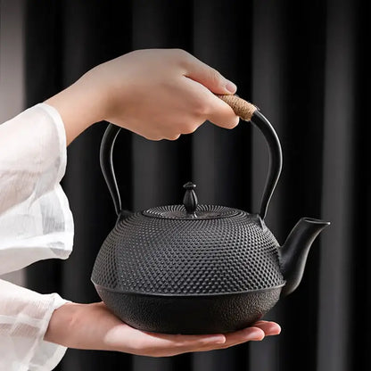 Textured black cast iron tea pot with infuser kitchen steeper