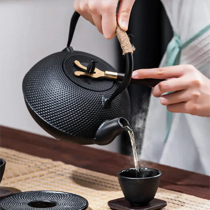 Textured black cast iron tea pot with infuser kitchen steeper