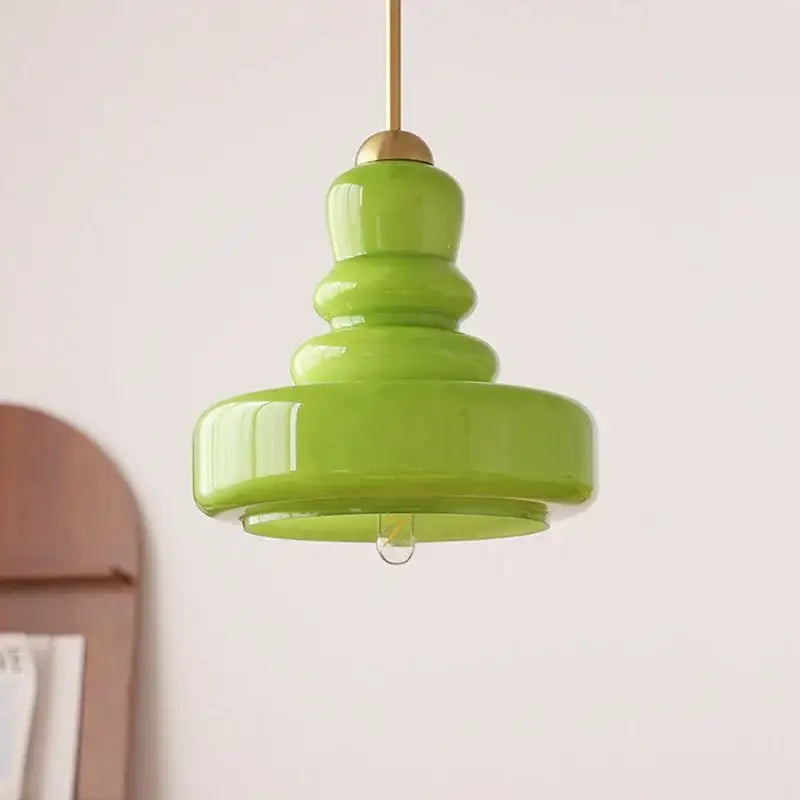 Tiered yellow glass pendant lights with brass accents for kitchens