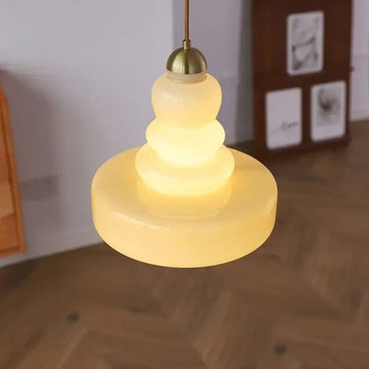 Tiered yellow glass pendant lights with brass accents for kitchens